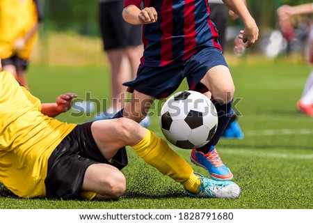 Soccer football tackle moment. Skill of tackling in soccer game. Two footballers in a duel. Running school age boys. Kids kicking soccer ball on grass pitch Royalty-Free Stock Photo #1828791680