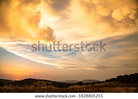 Sky with stunning yellowish clouds between mountains Royalty-Free Stock Photo #1828805255