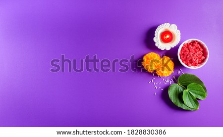 Happy Dussehra. Yellow flowers, green leaf and rice on purple pastel background. Dussehra Indian Festival concept. Royalty-Free Stock Photo #1828830386
