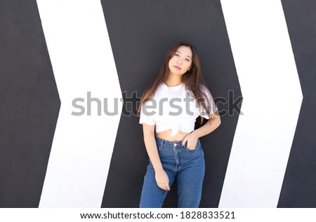 Portrait of cute Japanese woman standing in front of scratched wall with copy space for advertisement, promotional content or logo