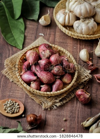 Shallot in a rustic bamboo plate. Brown wood textured background. Selective focus
