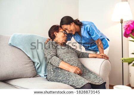 Portrait of young Asian nurse with elderly woman. Helpful volunteer taking care of senior lady at healthcare home. Picture of a senior lady with her friendly caregiver.