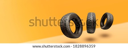 winter tires - panoramic concept with copyspace for the site header on a bright orange background. sale of tires or spare parts for the car. Royalty-Free Stock Photo #1828896359