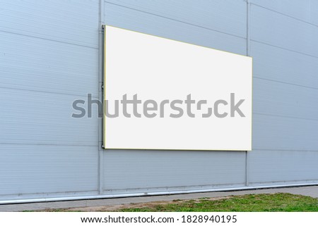 spacious white empty commercial banner with mockup hanging on gray wall of supermarket or store outside