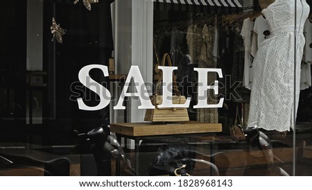 White text on the glass window of the store with the inscription sale