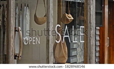 White text on the glass window of the store with the inscription sale
