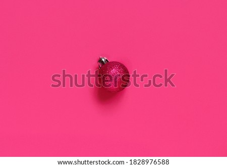 Pink Christmas bauble on a pink background top view