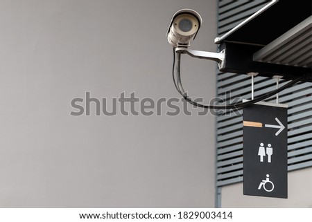 Lavatory restroom sign on black board sticked under the roof near outdoor CCTV in public toilet with copy space. 