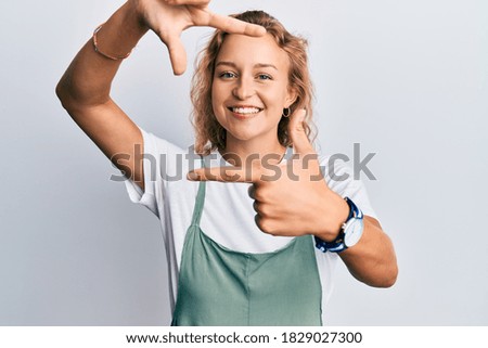 Beautiful caucasian woman wearing casual clothes smiling making frame with hands and fingers with happy face. creativity and photography concept. 