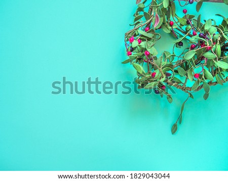 Christmas crown isolated on green background. Wreath decoration for hanging at home during winter holidays. Copy space.