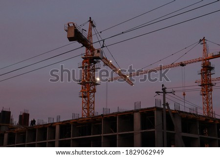 tower cranes build houses in the fall