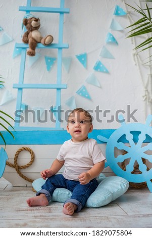 a small boy is sitting on the floor next to a wooden boat