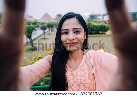 Young beautiful woman smiling happy walking in city park on a sunny day of summer taking a selfie photo using smartphone