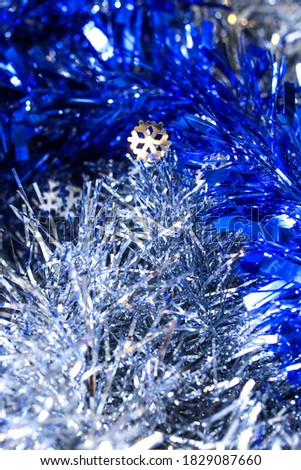 Closely blue and silver sparkling garlands for the Christmas tree. New year abstract background.  Vertical shot