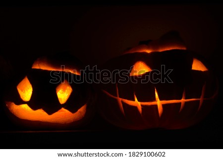 Two different  glowing Halloween Pumpkins isolated on black background at night