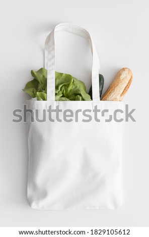 White tote bag mockup with groceries on a white table. Royalty-Free Stock Photo #1829105612