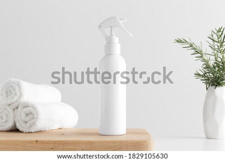 White cosmetic trigger sprayer bottle mockup with towels and a rosemary on a wooden table. Royalty-Free Stock Photo #1829105630