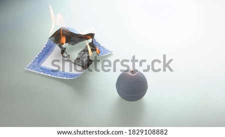 Round candle and burning stock certificate. Concept of crisis and world economy collapse.