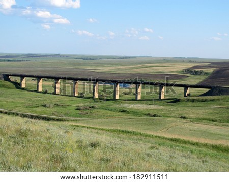 Old viaduct against a blue sky in the steppe