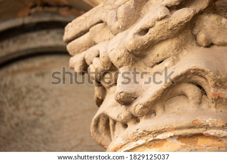 Architectural detail of an ancient Ionic capital. Architectural ornament on the facade. Stone figure.