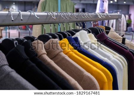 woolen sweaters with a collar on hangers on the counter in the store. Shallow depth of field.
