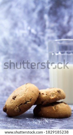 American gluten free chocolate chip cookies with glass glass of vegetable milk on gray background. Chocolate chip cookies. Sweet pastries, dessert. Culinary background. Vertical photography.