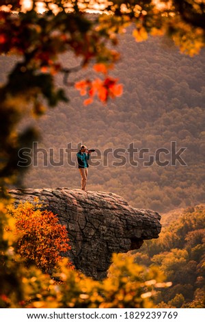 A man takes a photograph from the edge of Whitaker Point, also known as Hawksbill Crag, in Central Arkansas Royalty-Free Stock Photo #1829239769