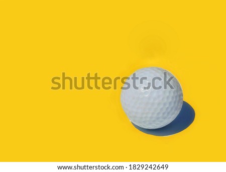 White golf ball on golden yellow background