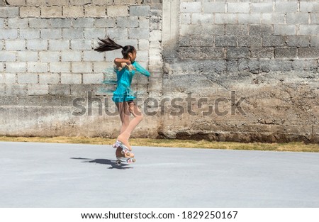 Teenage girl jumping on roller skates during a training session. Outdoor figure skating element