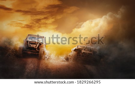 Two off road vehicles coming out of a mud hole hazard in off-road  competition. Royalty-Free Stock Photo #1829266295