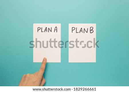 Choose Plan A with finger on blue background. Business plan, choice, change, dilemma concept. top view