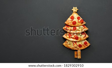 Pieces of pizza set like christmas tree. Christmas and New year concept. Top view, copy space
