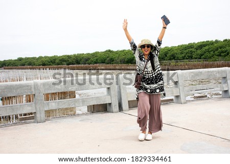 Travelers thai women travel visit relax and take photo on concrete bridge in sea ocean at Bangpu Recreation Center in Samut Prakan, Thailand