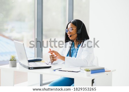 Portrait of african american happy smiling young doctor in headset consulting patient over the phone. Health care call center online concept Royalty-Free Stock Photo #1829353265