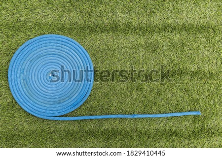 blue rope wound in a circle on the green grass