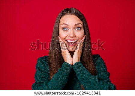 Photo of positive girl feel astonished touch cheeks hands wear pullover isolated over bright red color background