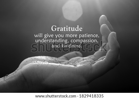 Inspirational quote - Gratitude will give you more patience, understanding, compassion, and kindness. With open palm hand receiving the light concept on black and white abstract art background.