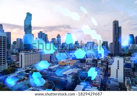 Hologram of abstract technology glowing icons, panoramic cityscape of Bangkok at sunset, Asia. The concept of worlds technological changes. Double exposure.