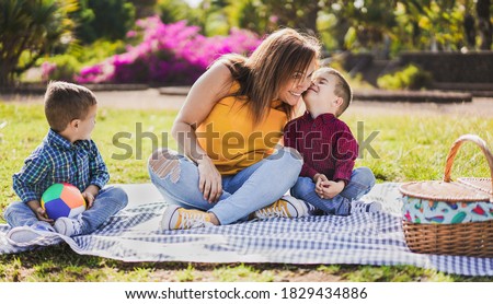 Mother and children enjoy pic nic in nature park - Family, mother and twin sons love