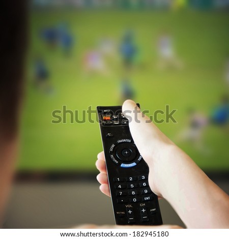  boy is watching a television screen with his back
