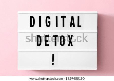 Lightbox with phrase DIGITAL DETOX on pink background, top view