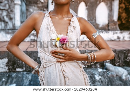 close up of young woman in beautiful white dress sitting outdoors