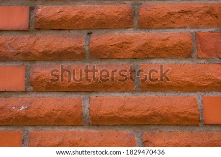 Texture of a red vintage brick wall of a building close up