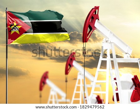 Oil rigs against the backdrop of the colorful sky and a flagpole with the flag of Mozambique. The concept of oil production, minerals, development of new deposits.