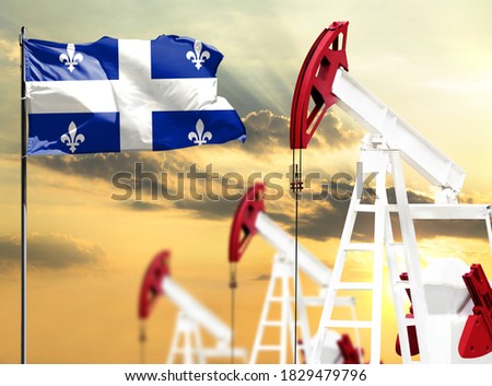 Oil rigs against the backdrop of the colorful sky and a flagpole with the flag of Quebec. The concept of oil production, minerals, development of new deposits.