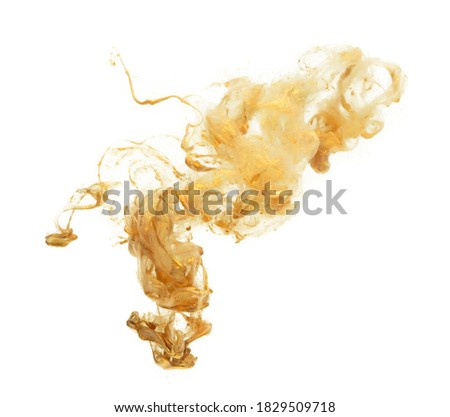 Gold paint glistening in water. Dissolving spreading abstract ink stain