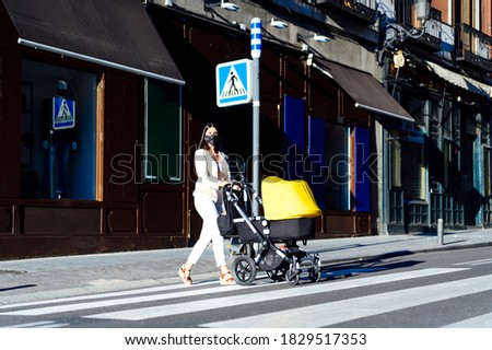 young mother with baby carriage walking. woman with baby trolley.