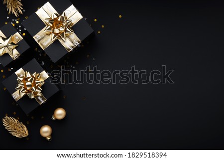 Merry Christmas and Happy Holidays greeting card, frame, banner. New Year. Noel. Gold Christmas gifts, ornaments on black background top view. Winter holiday xmas theme. Flat lay.