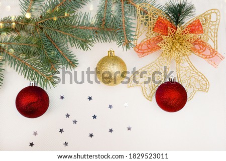Spruce branch decorated with red and gold balls on a white background. Christmas picture. Close-up