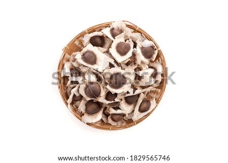 Flat lay, top view dried Moringa seeds in a bamboo basket isolated on white background.